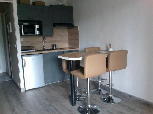 une cuisine avec une table et des chaises dans une pièce dans l'établissement STUDIO VENTOUX, à Mollans-sur-Ouvèze