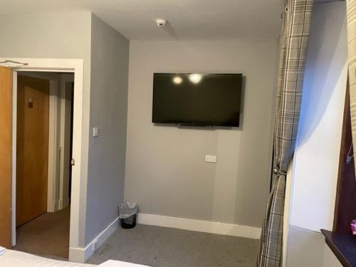 a bedroom with a flat screen tv on the wall at Commercial Hotel (Insch) in Insch