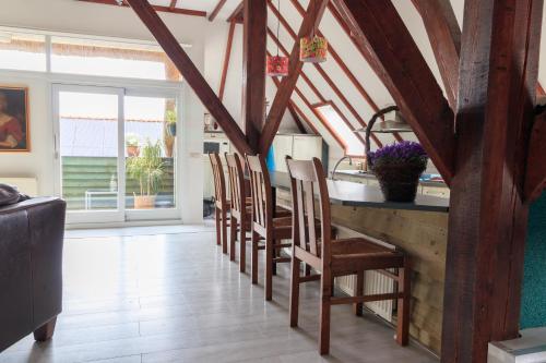 a kitchen with wooden beams and a counter with chairs at Het Grote Paard in Havelte