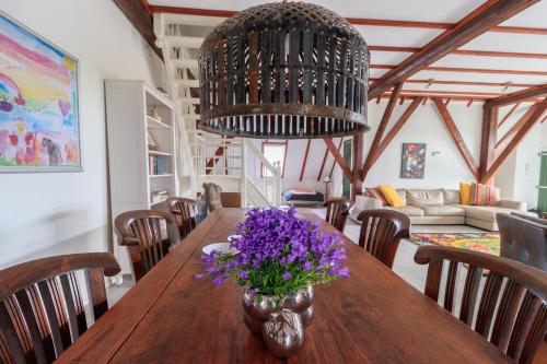 a dining room with a table with purple flowers on it at Het Grote Paard in Havelte