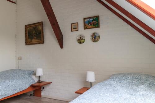 a bedroom with two beds and pictures on the wall at Het Grote Paard in Havelte