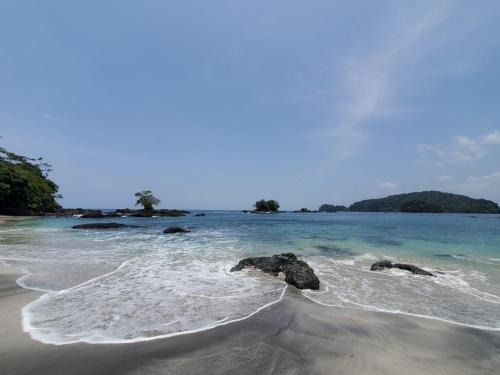 a beach with some rocks in the water at Posada El Esfuerzo in Nuquí