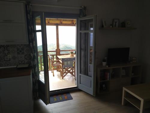 a room with a door open to a balcony with a table at Eden View in Sotír
