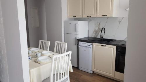 uma cozinha com uma mesa e um frigorífico branco em Apartamenty Gdańsk Angielska Grobla em Gdansk