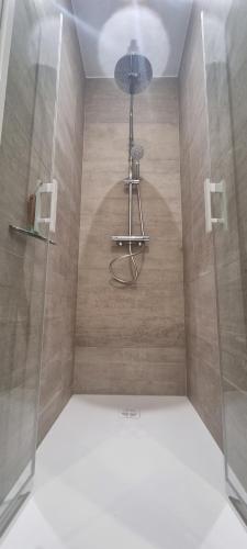 une salle de bain avec une douche avec une porte vitrée dans l'établissement Charmant T2 coeur de village avec stationnement, à Banyuls-sur-Mer