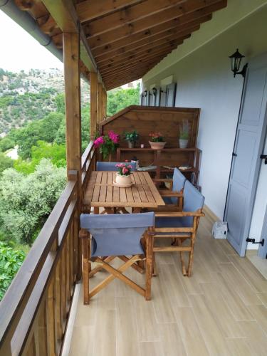 a deck with a wooden table and chairs on a balcony at Eden View in Sotír