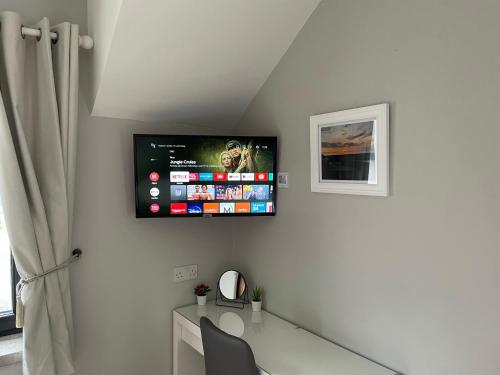 a room with a desk and a tv on the wall at The Cé Hideout in Tralee