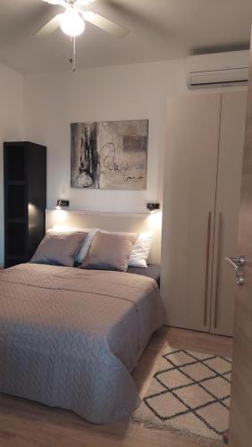 a bedroom with a bed and a ceiling fan at Apartmani Stipe in Drage