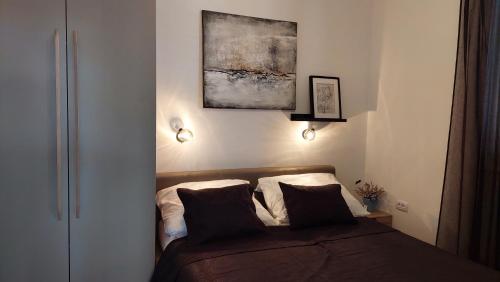 a bedroom with a bed and a painting on the wall at Apartmani Stipe in Drage