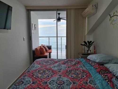 a bedroom with a bed with a view of the ocean at Apto Frente al Mar. Vista genial al Pacífico in San Carlos