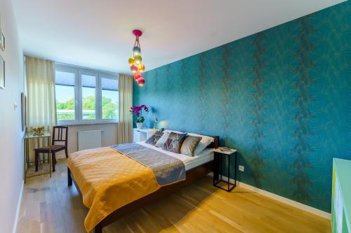 コウォブジェクにあるSUN 7 - osiedle JANTARの青い壁のベッドルーム1室(ベッド1台付)