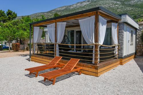 une petite cabine avec deux chaises devant elle dans l'établissement Larisa, à Orebić