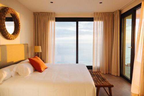 a bedroom with a large bed and a large window at Anamcara Suites in Las Indias