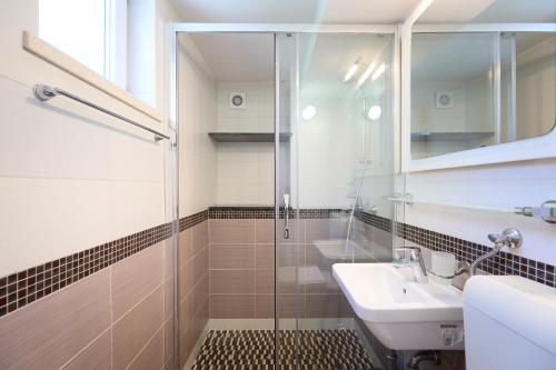 un bagno con doccia in vetro e lavandino di Bay View House a Zaton