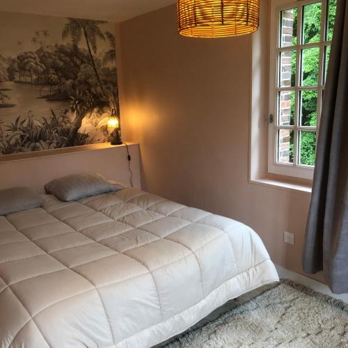a white bed in a bedroom with a window at Le Rucher in Bois-Normand-près-Lyre