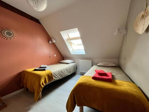 2 camas en una habitación pequeña con ventana en Les Gîtes du Florival, la Glycine, en Soultz-Haut-Rhin