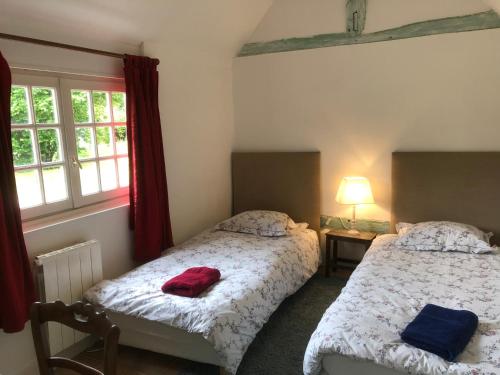 um quarto com 2 camas e uma janela em Le Rucher em Bois-Normand-près-Lyre