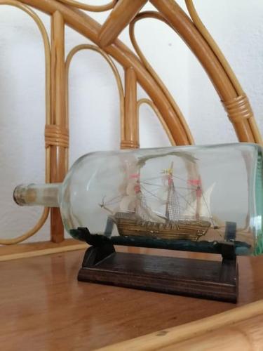 a miniature ship in a glass container on a table at Apartments Vedrana in Ražanj