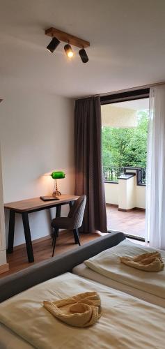 Schlafzimmer mit einem Schreibtisch, einem Bett und einem Tisch in der Unterkunft Appartementhaus Wimmerhof in Bad Füssing