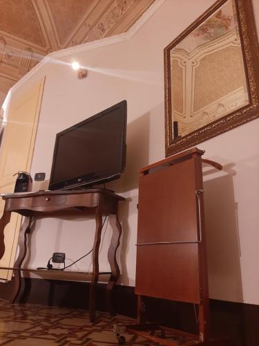 a television sitting on a table in a room at Vera Rooms in Catania