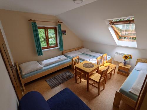 a room with two bunk beds and a table and chairs at Penzion Jezero in Vranov nad Dyjí
