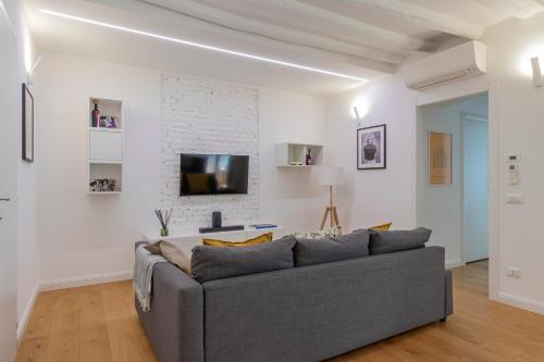sala de estar con sofá gris y pared blanca en Castaldi 18 - Milano in tasca en Milán