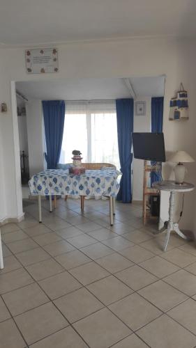 sala de estar con mesa y cortinas azules en Suite CielAzzurro, en Arezzo