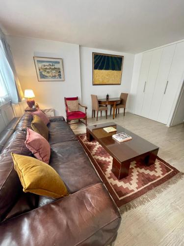 un salon avec un canapé en cuir et une table dans l'établissement Grand T2 Plein centre historique avec ascenseur, à Saint-Jean-de-Luz