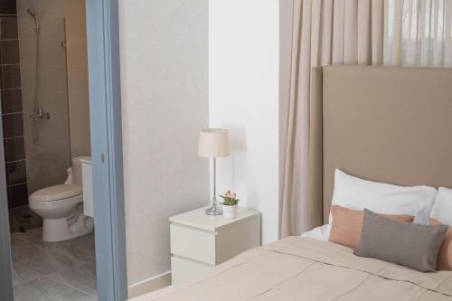 1 dormitorio con 1 cama y baño con aseo en New Modern Lux City Condo With Pool And Gym Ocean View Santo Domingo, en Ciudad Nueva