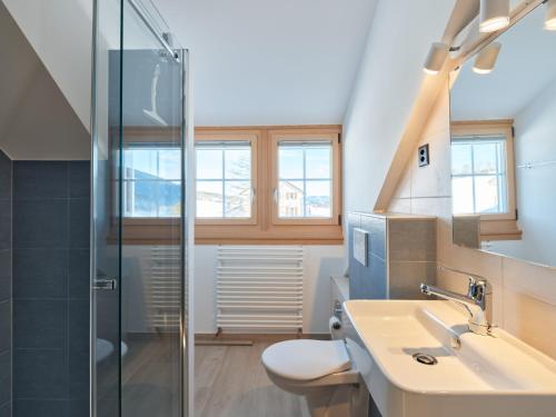 a bathroom with a toilet and a sink and a shower at Jurabelle in La Côte-aux-Fées