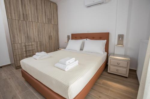 a bedroom with a bed with two towels on it at Raise Kifisias Serviced Apartments in Athens