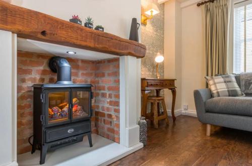 a living room with a fireplace with a stove at Stunning 2 bed Cottage in Saddleworth in Dobcross