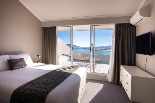 a hotel room with a bed and a balcony at Rydges Horizons Snowy Mountains in Jindabyne