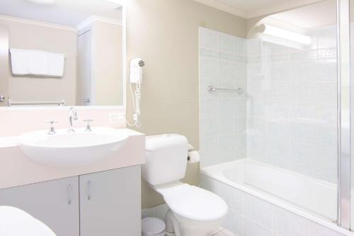 a white bathroom with a sink and a toilet at Rydges Horizons Snowy Mountains in Jindabyne