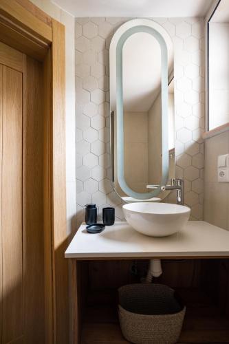 a bathroom with a white sink and a mirror at Rajskie Uroczysko Apartamenty Jacuzzi Sauna in Rajskie Sakowczyk