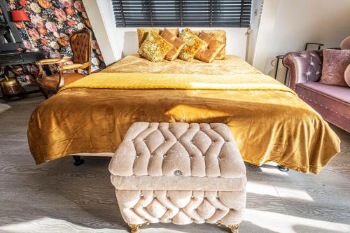 a bedroom with a large bed with a gold bedspread at Mylos Studios in Alkmaar