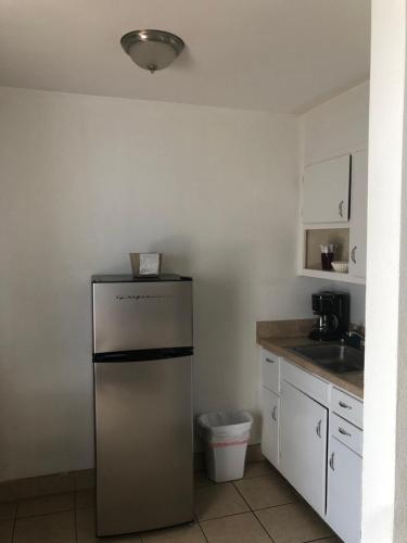 a small kitchen with a refrigerator and a sink at Holiday Isles Resort in St Pete Beach