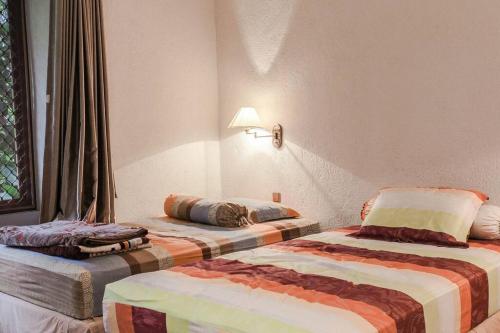 une chambre d'hôtel avec deux lits dans une chambre dans l'établissement VILLA BATU Luxurious privacy 3BR villa@ klub bunga, à Batu