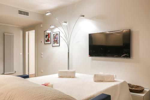 een slaapkamer met een bed en een flatscreen-tv aan de muur bij Treviso City Town 3 in Treviso