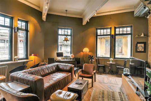 a living room with a leather couch and chairs at Ba Hao Residence in Bangkok