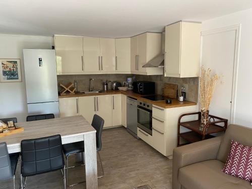 a kitchen with white cabinets and a table and a couch at Le domaine des Petits Princes in Lorgues