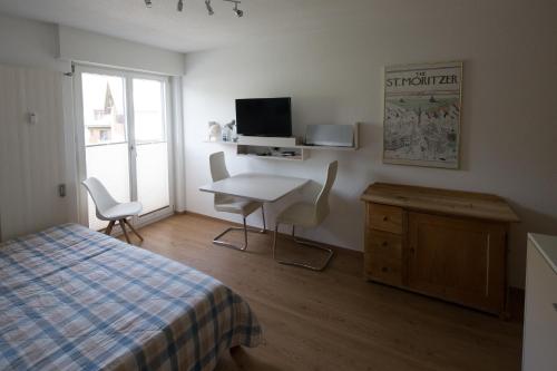 Schlafzimmer mit einem Bett, einem Tisch und einem Schreibtisch in der Unterkunft Chesa Surlej Apartment in Surlej
