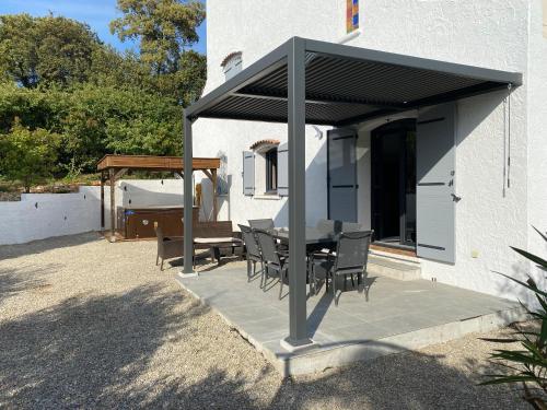 a patio with a table and chairs under a roof at Le domaine des Petits Princes in Lorgues
