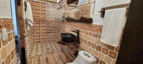 a small brick bathroom with a toilet and a pan at Hotel Campestre San Joaquin in Garzón