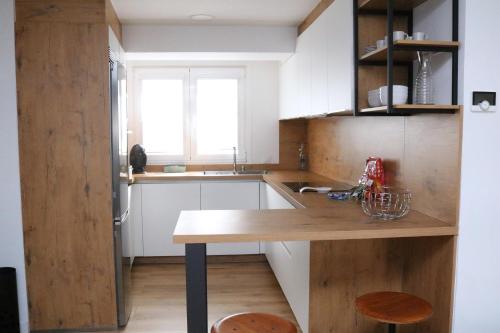 a kitchen with white cabinets and a wooden counter top at Tu Rincón en Compostela in Santiago de Compostela