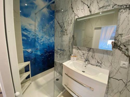 łazienka z białą umywalką i lustrem w obiekcie Esprit MALDIVES ...... SPA LOVE au coeur de Mulhouse w Miluzie