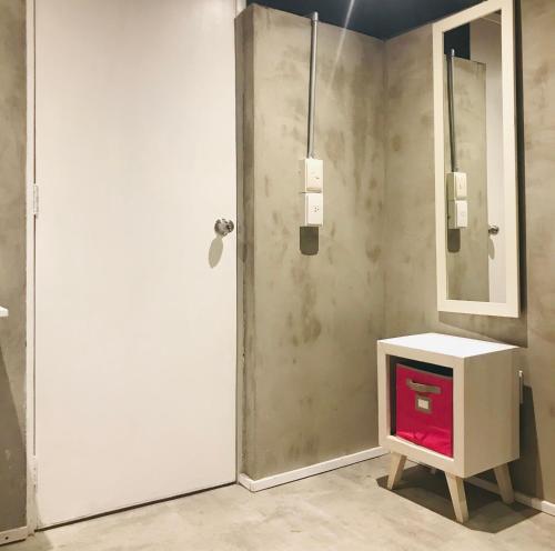 a bathroom with a white door and a tv at Hostal Regina Down Town Mexico City in Mexico City