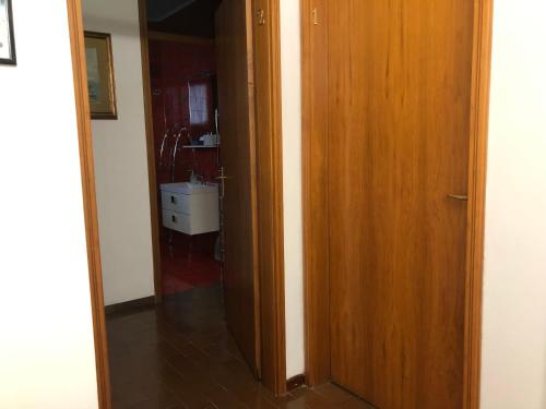 a hallway with a wooden door leading to a bathroom at B & B Chic in Premariacco