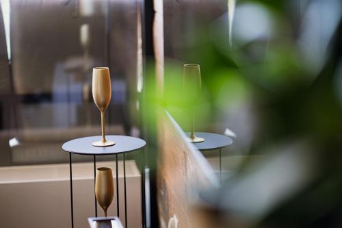 due bicchieri da vino seduti sui tavoli in una finestra di Golden Apartments Mountain Aparts a Świeradów-Zdrój