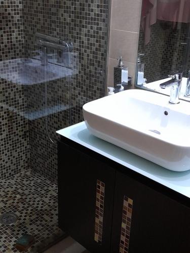 a bathroom with a white sink and a shower at Casa da Nau in Vila do Conde